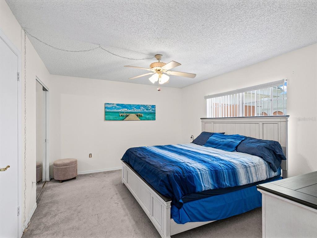 A living room and dining area feature beige carpet, a ceiling fan, and coastal decor — 6800 20TH AVENUE N UNIT 503, ST PETERSBURG, FL