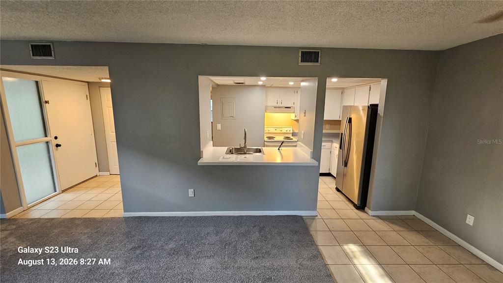A view from a carpeted living area toward a kitchen with a breakfast bar — 7 CASTANIA COURT, ST AUGUSTINE, FL