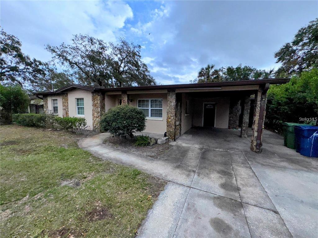 A single-story house with a stone facade, a concrete driveway, and an attached carport — 3011 E FLORA STREET, TAMPA, FL