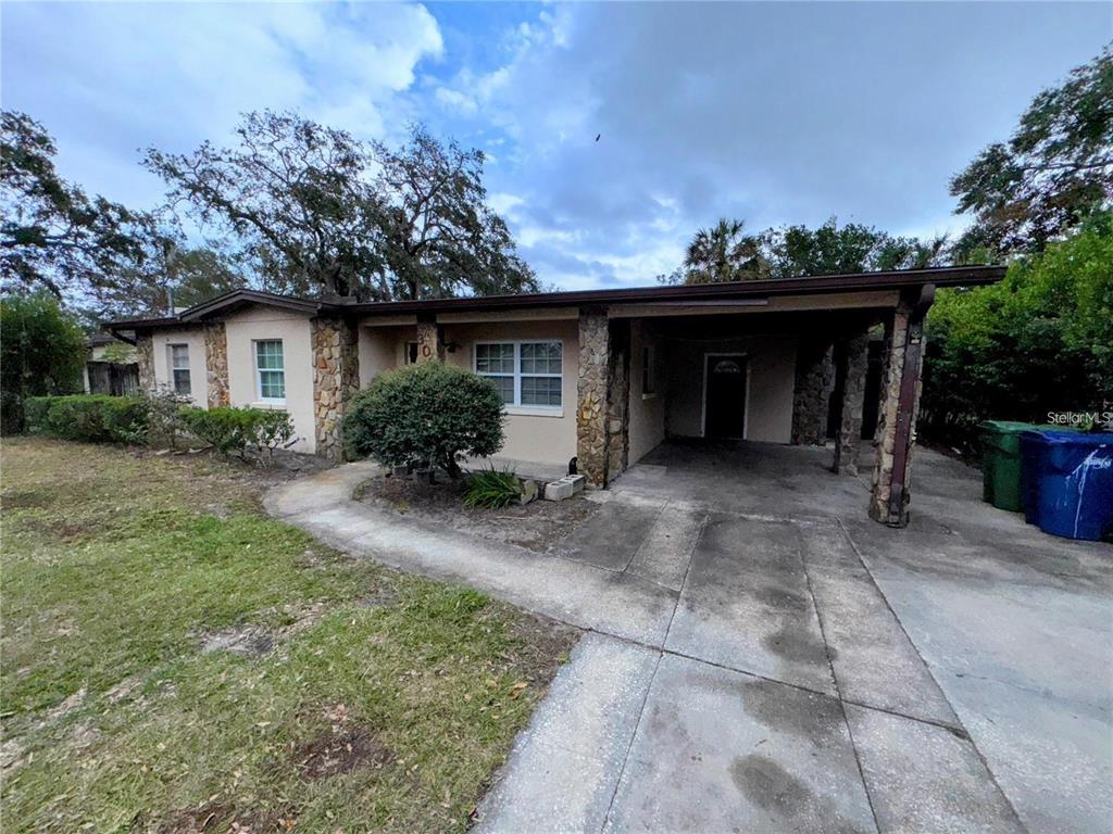 A single-story house with a stone facade, a carport, and a concrete walkway — 3011 E FLORA STREET, TAMPA, FL