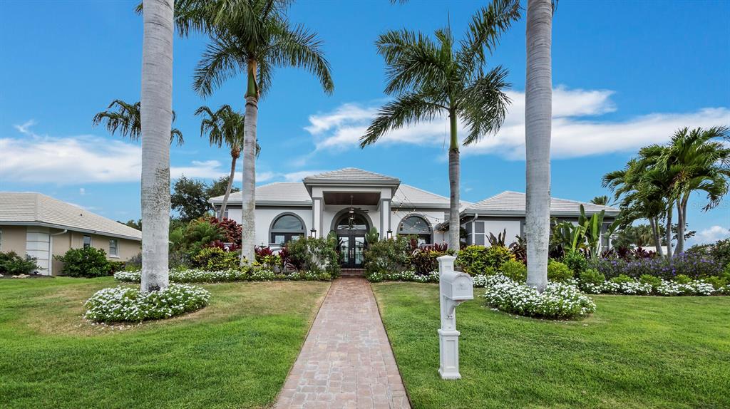 A single-story house with a paved walkway, white mailbox, and palm trees on a lawn — 206 FOUR KNOT LANE, OSPREY, FL