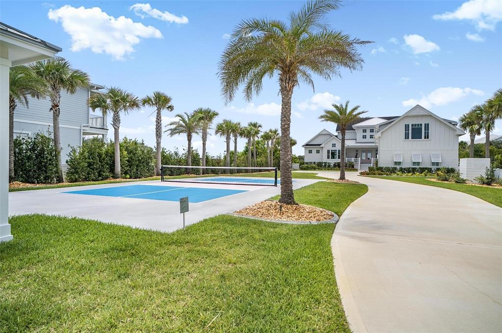 A pickleball court sits on a concrete pad next to a driveway and large house — 8065 A1A S, ST AUGUSTINE, FL