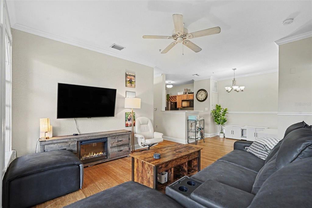 A living room features a dark sectional sofa, a wooden coffee table, and a fireplace console — 5000 CULBREATH KEY WAY UNIT 4-101, TAMPA, FL