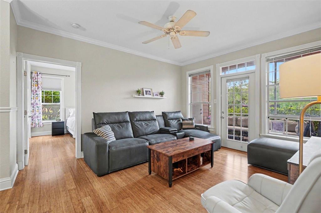 A living room features a gray sectional sofa, a wooden coffee table, and hardwood floors — 5000 CULBREATH KEY WAY UNIT 4-101, TAMPA, FL