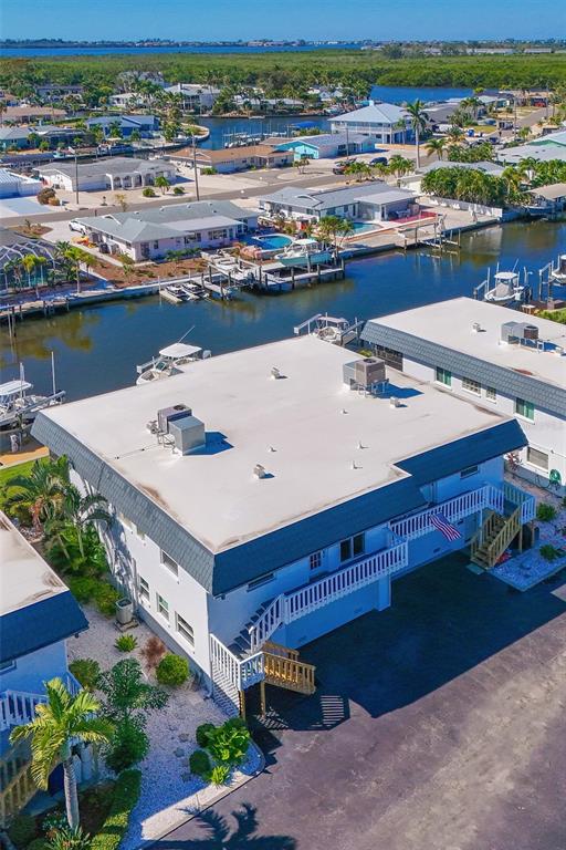 An elevated view shows a multi-story apartment building with a flat roof near a canal — 10313 WATERBIRD WAY, BRADENTON, FL