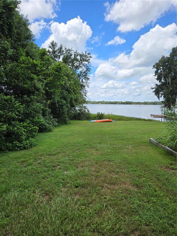 A wooden footbridge crosses a small pond in a lush, landscaped backyard — 18249 ROSE STREET, GROVELAND, FL
