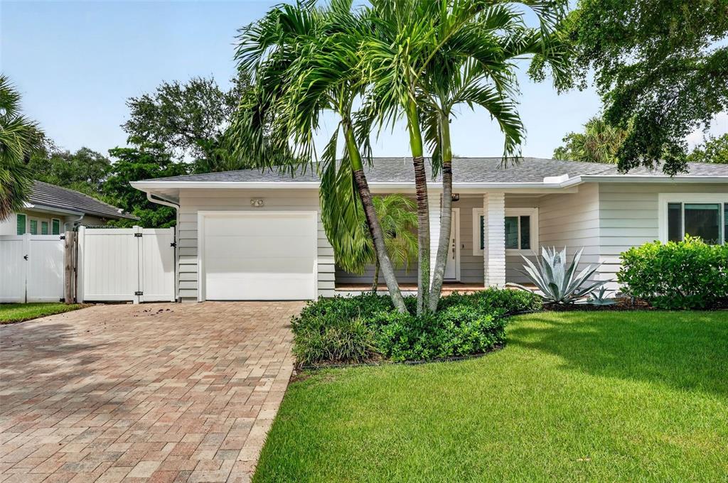 A single-story house with a paved driveway, white garage door, and palm trees in front — 1965 HIBISCUS STREET, SARASOTA, FL