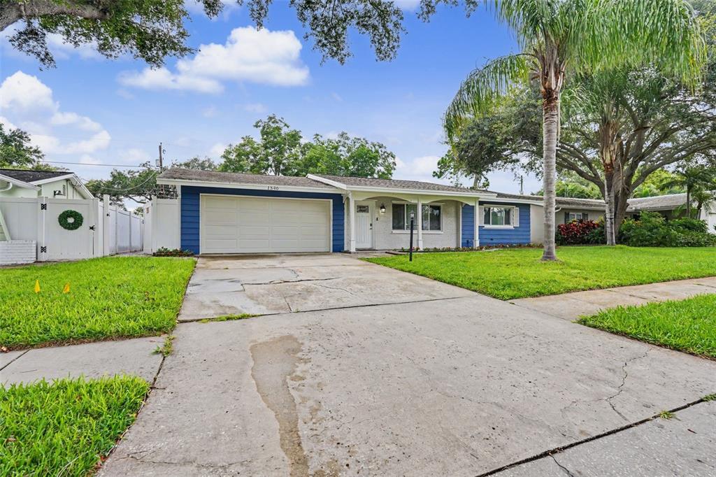 A single-story house with a blue and white exterior, a garage, and a concrete driveway — 1340 WILLIAMS DRIVE, CLEARWATER, FL