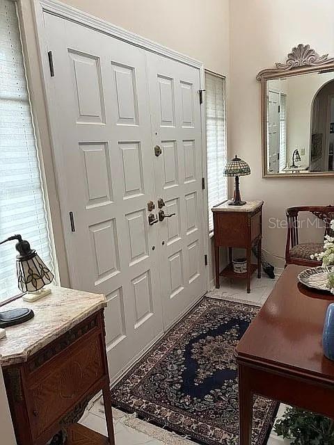 An entryway features white double doors, a dark wood side table, and an ornate wall mirror — 4018 CORRIENTES COURT E, JACKSONVILLE, FL