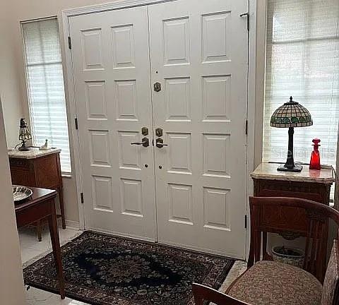 A white double door entryway features a patterned area rug and two wooden side tables — 4018 CORRIENTES COURT E, JACKSONVILLE, FL