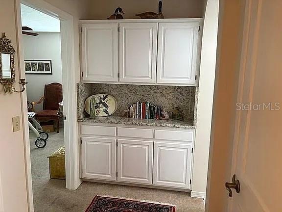 A white built-in cabinet with granite countertops is situated in a hallway — 4018 CORRIENTES COURT E, JACKSONVILLE, FL