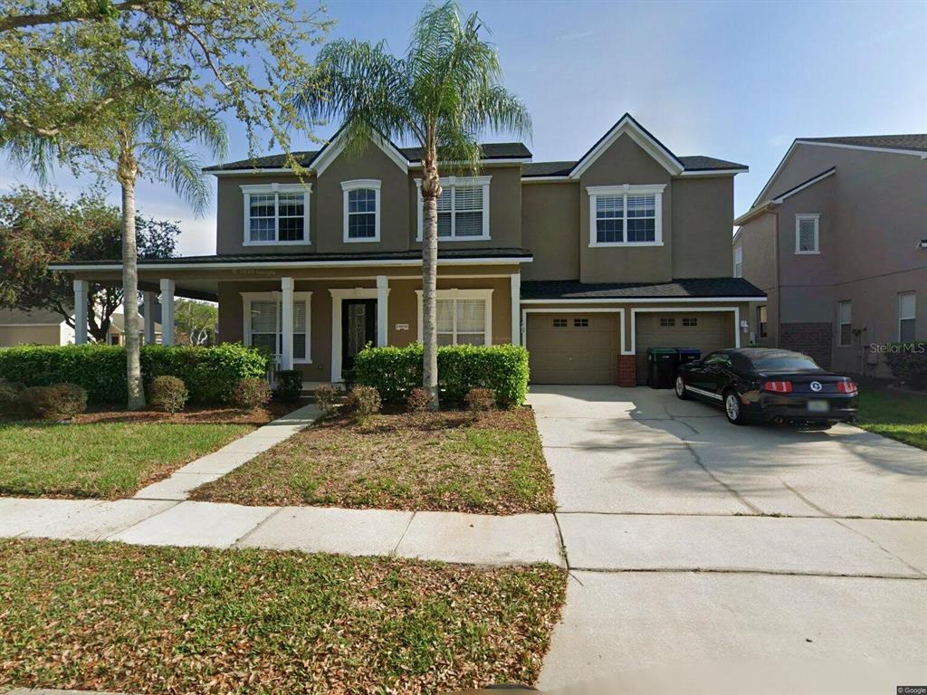 A two-story house with a brown exterior, a front porch, and an attached two-car garage — 14636 MAILER BOULEVARD, ORLANDO, FL