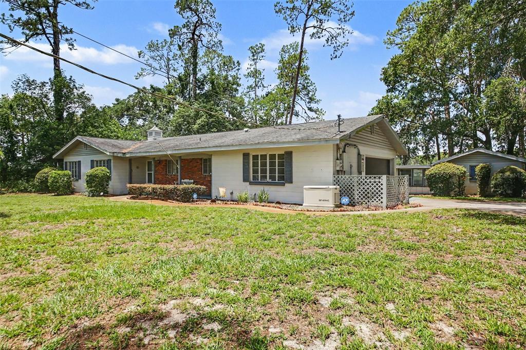 A single-story house with white siding, a brick accent wall, and an attached garage — 230 S CRYSTAL DRIVE, SANFORD, FL