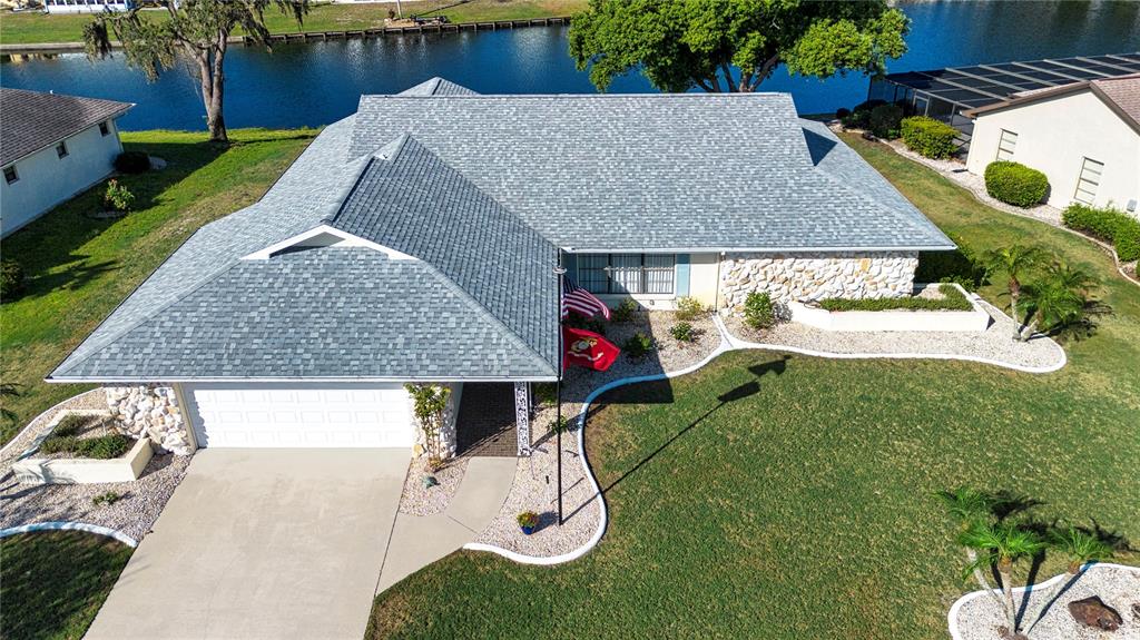 An aerial view of a single-story house with a gray shingled roof and stone facade — 2016 E VIEW DRIVE, SUN CITY CENTER, FL