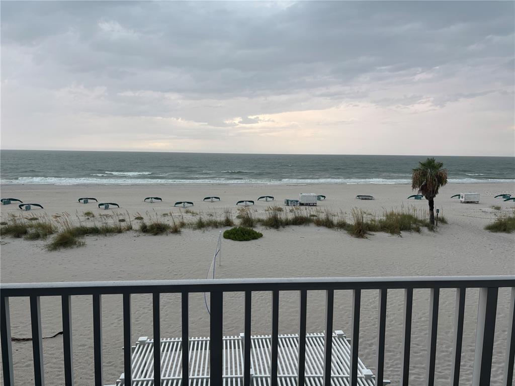 A view of a sandy beach and the ocean from a balcony with railings — 9980 GULF BOULEVARD UNIT 317, ST PETERSBURG, FL