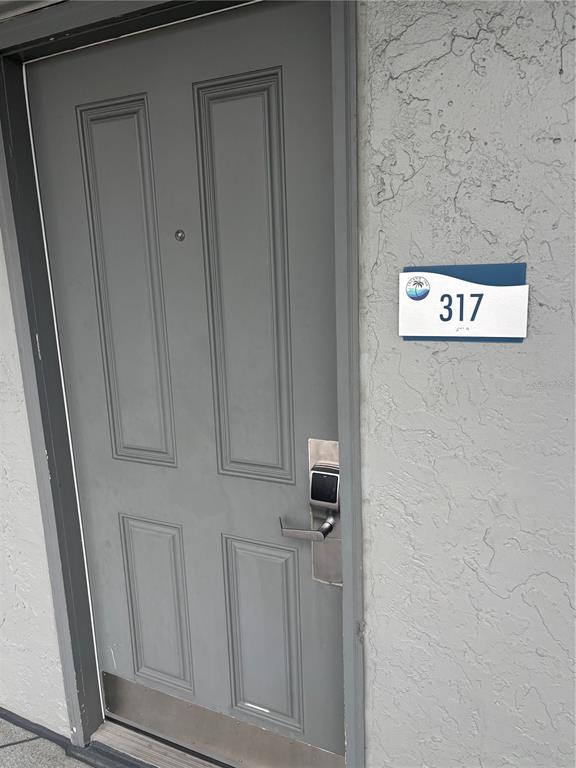 A gray hotel room door with an electronic lock and a room number sign — 9980 GULF BOULEVARD UNIT 317, ST PETERSBURG, FL