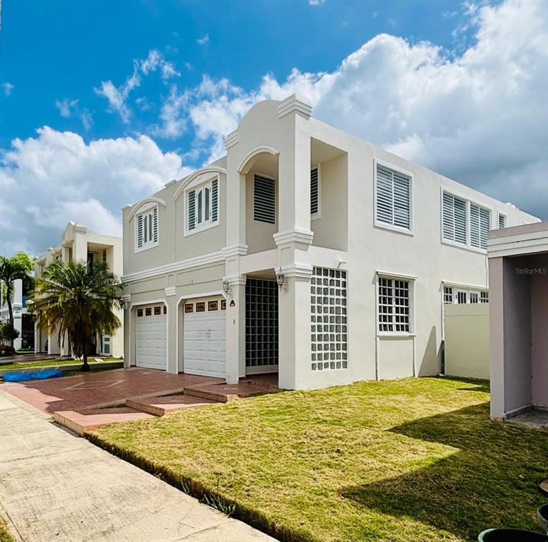 The exterior of a two-story beige house features a two-car garage and glass block accents — Plaza de las Fuentes PLAZA DE LAS FUENTES, TOA ALTA, PR