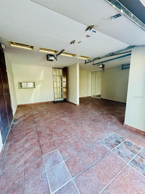 A tiled garage with a white ceiling, a glass door, and a sliding mirrored closet — Plaza de las Fuentes PLAZA DE LAS FUENTES, TOA ALTA, PR