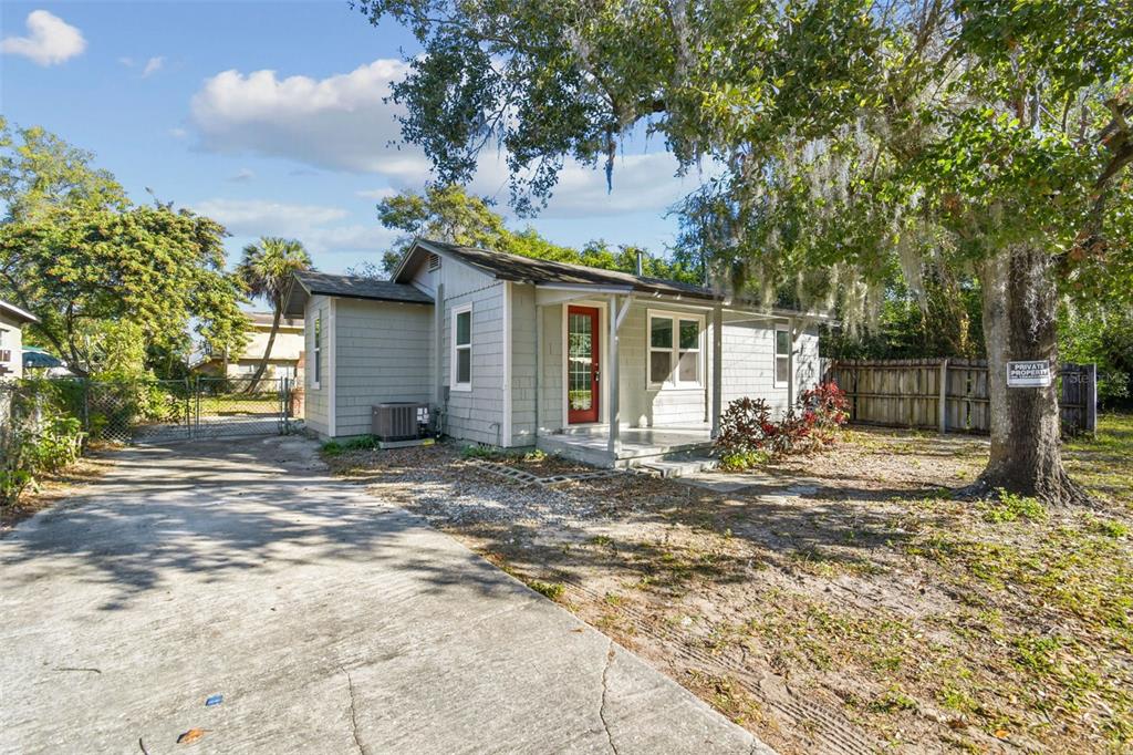 A single-story house with gray siding, a red front door, and a concrete driveway — 2308 EVERETT STREET, LAKELAND, FL