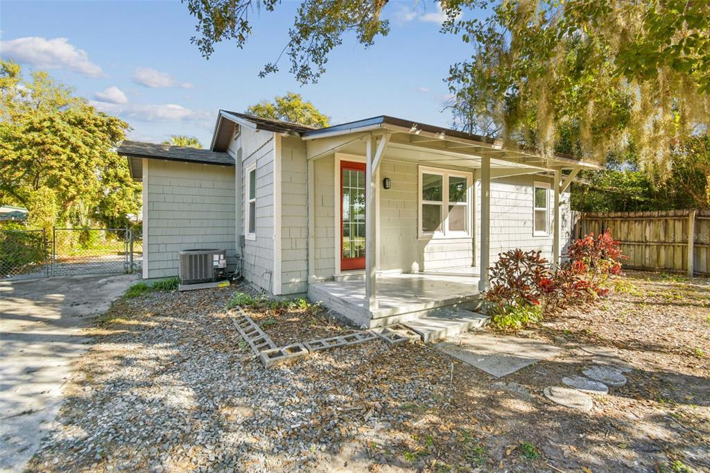A single-story house with light green siding, a red front door, and a covered porch — 2308 EVERETT STREET, LAKELAND, FL