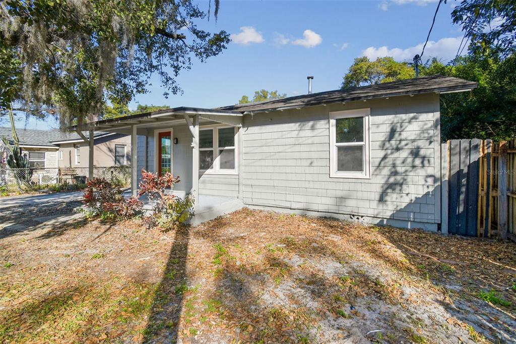 A gray, single-story house with a covered front porch and a red front door — 2308 EVERETT STREET, LAKELAND, FL