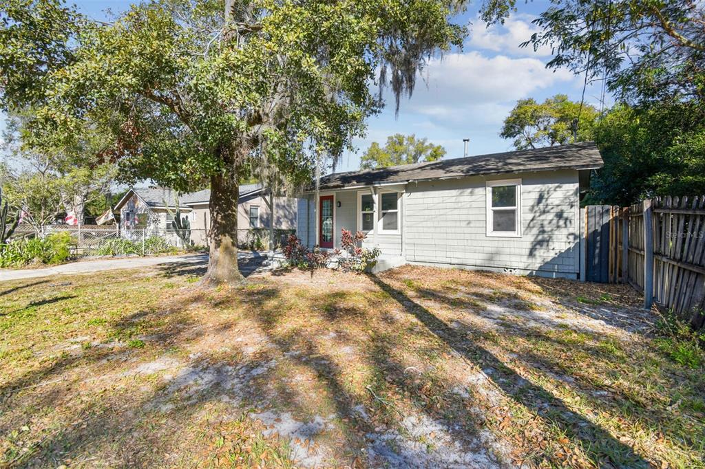 A single-story gray house with a red front door sits on a grassy lot — 2308 EVERETT STREET, LAKELAND, FL