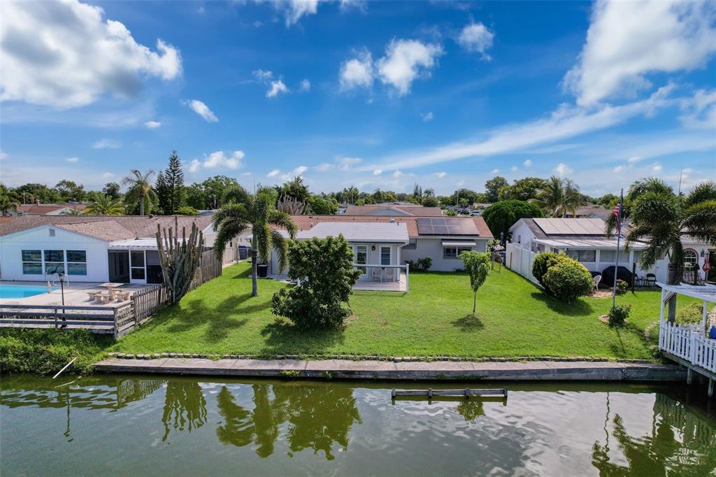 An aerial view of a waterfront house with a green lawn and a canal — 2349 HAMA DRIVE, HOLIDAY, FL