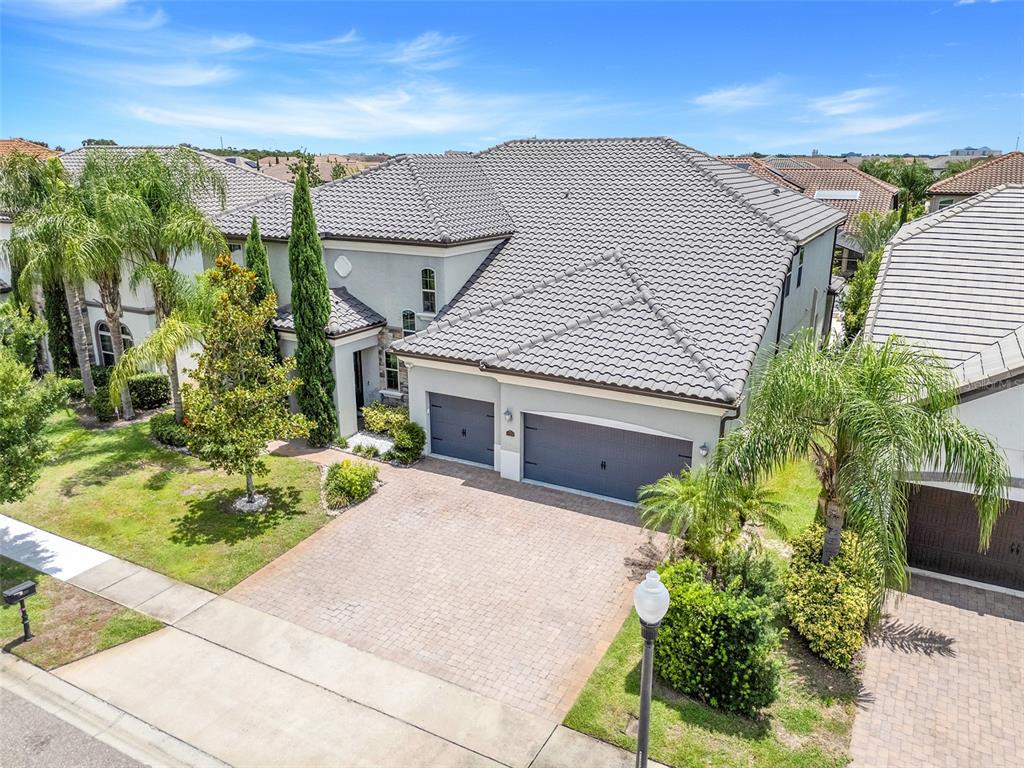 An aerial view of a two-story house with a gray tile roof and paver driveway — 7920 CHILTON DRIVE, ORLANDO, FL