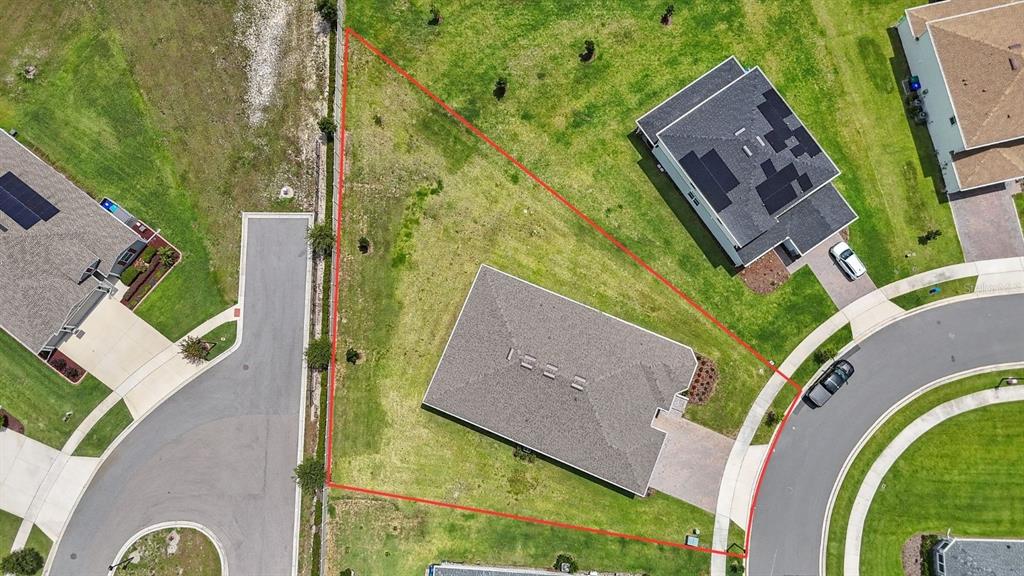An aerial view shows a single-family home situated on a large, irregularly shaped corner lot — 5173 FOOTHILLS PRESERVE LOOP, MOUNT DORA, FL