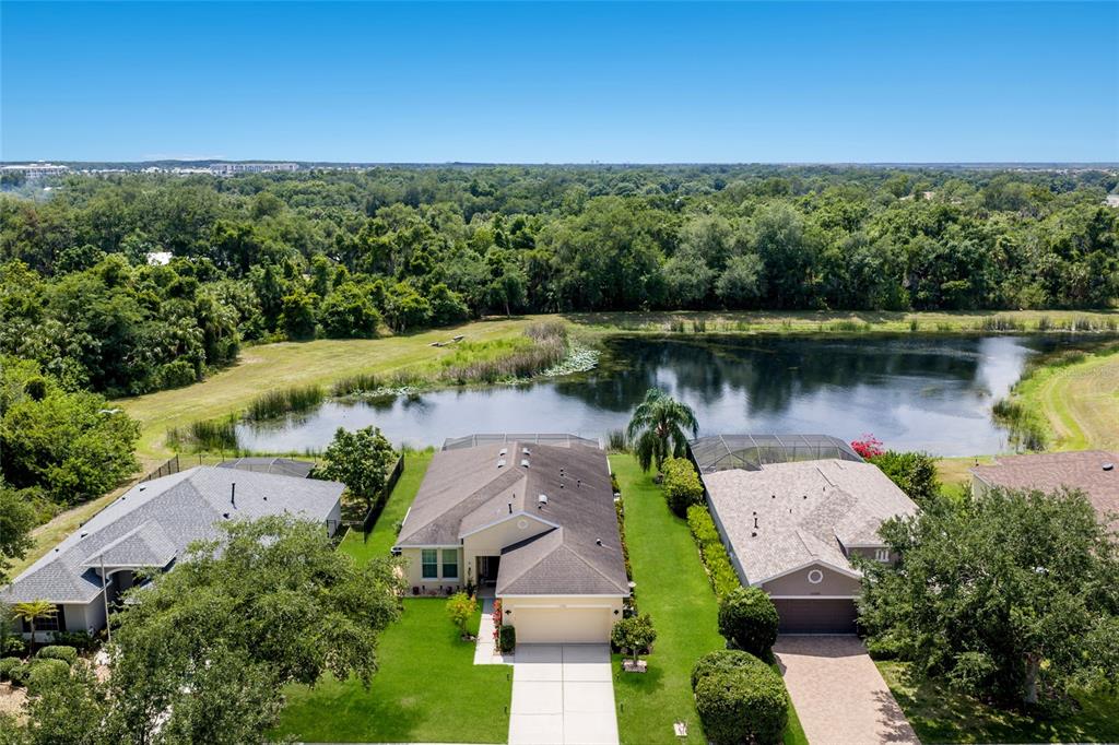 A single-story suburban house with a tan exterior, a two-car garage, and a green lawn — 12287 LAVENDER LOOP, BRADENTON, FL