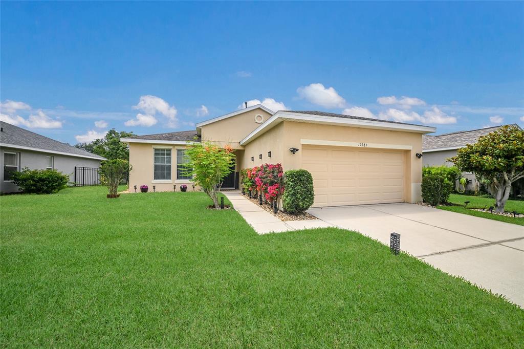 A bright entryway features tile flooring, a console table, and a white front door — 12287 LAVENDER LOOP, BRADENTON, FL
