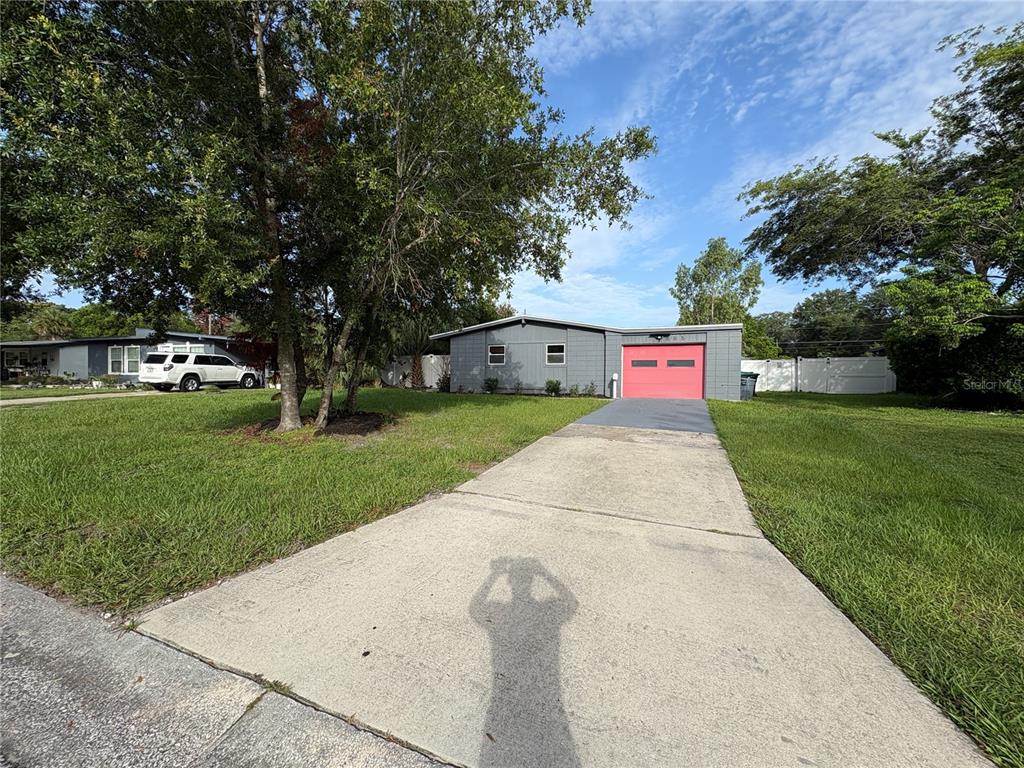A gray single-story house with a bright pink garage door and a concrete driveway — 885 CARNATION DRIVE, WINTER PARK, FL