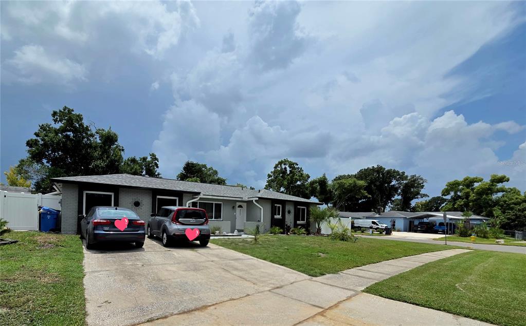 A single-story house with a gray brick exterior, a concrete driveway, and two parked cars — 2245 ELIZABETH DRIVE, BRANDON, FL