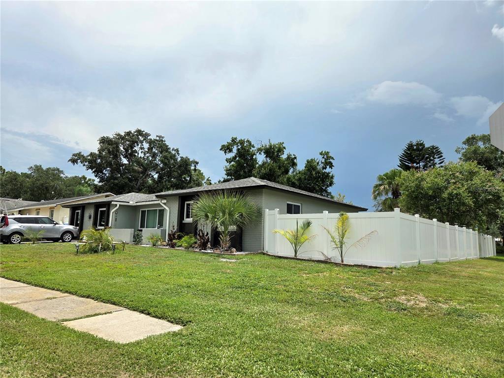 A single-story house with a gray brick exterior and a white vinyl privacy fence — 2245 ELIZABETH DRIVE, BRANDON, FL
