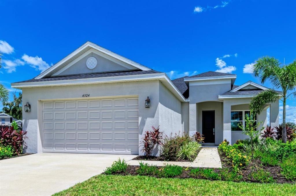 A single-story house with a beige stucco exterior, a two-car garage, and a front entryway — 4324 SEA MARSH PLACE, PARRISH, FL