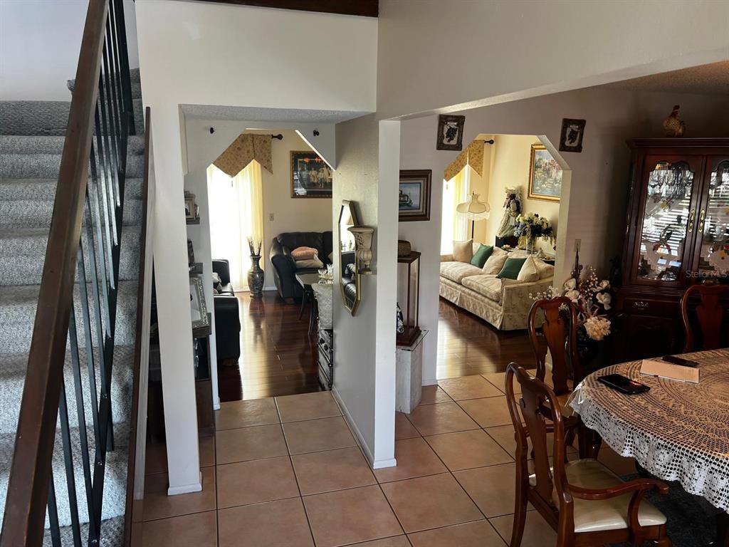 A view from a tiled entryway looking toward a living room and dining area — 7804 SNOWBERRY CIRCLE, ORLANDO, FL