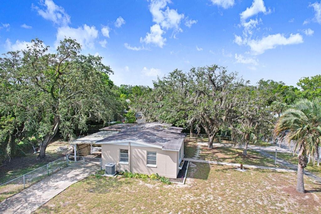 An aerial view of a single-story house with a flat roof and large oak trees — 1228 ACADEMY AVENUE, SPRING HILL, FL