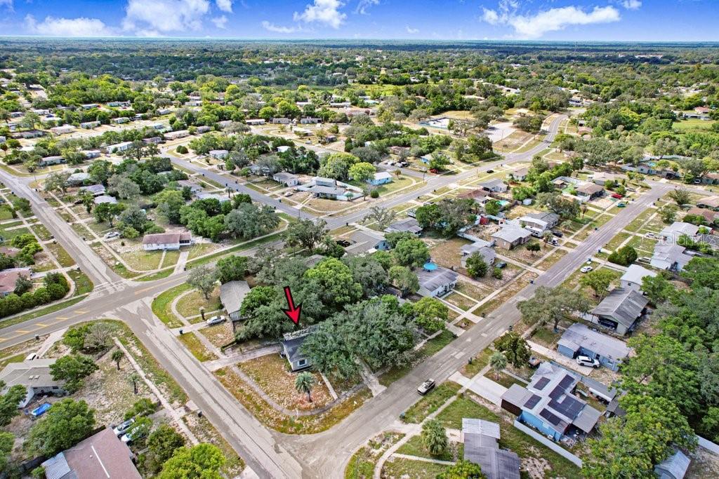 An aerial view of a residential neighborhood featuring a house marked with a red arrow — 1228 ACADEMY AVENUE, SPRING HILL, FL