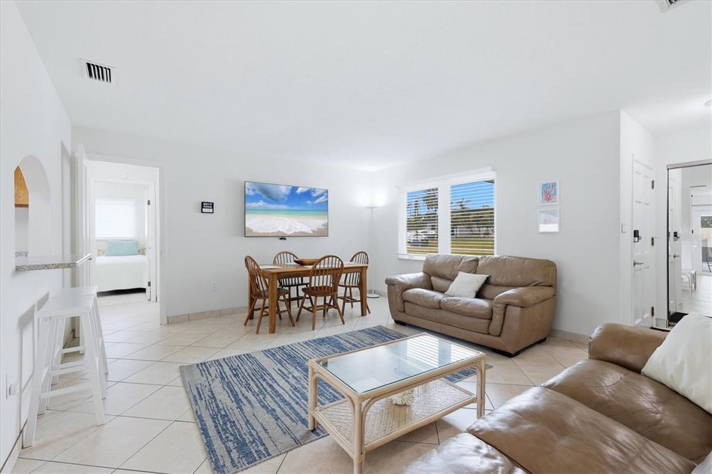 A living and dining area features tile floors, tan leather sofas, and a wall-mounted television — 6309 FLAMINGO DRIVE, APOLLO BEACH, FL