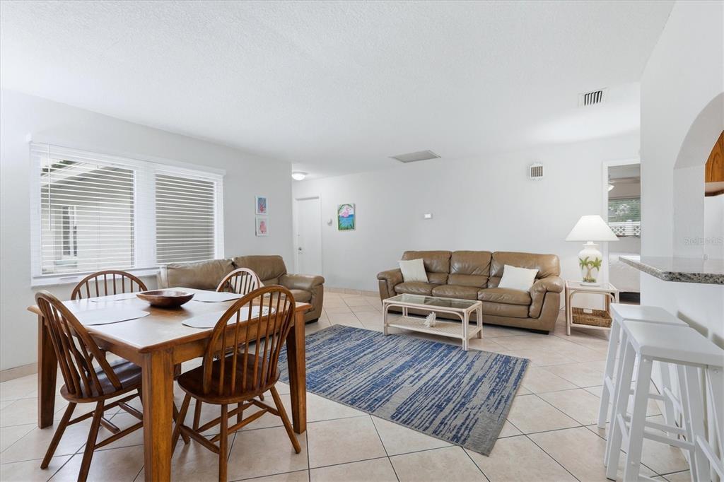 A living and dining area features tile floors, a brown leather sofa, and wooden furniture — 6309 FLAMINGO DRIVE, APOLLO BEACH, FL