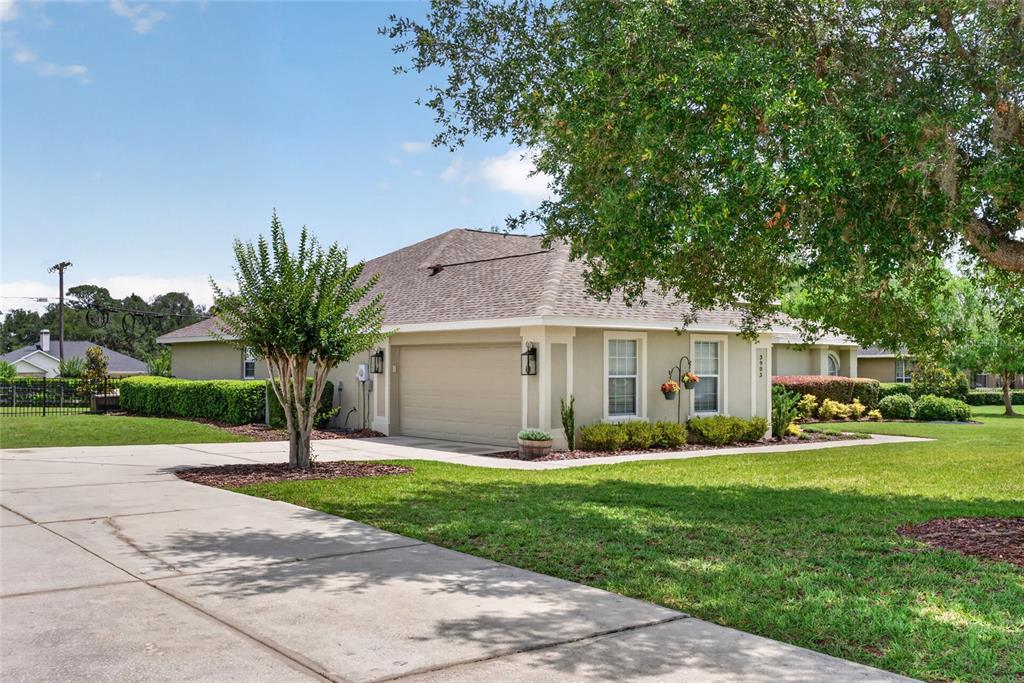 A single-story house with a beige exterior, a two-car garage, and a large front lawn — 3903 SE 38TH LOOP, OCALA, FL
