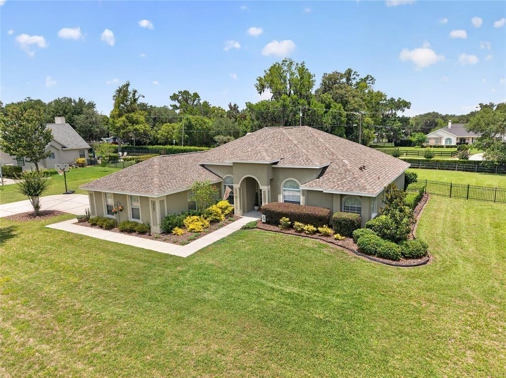 An aerial view shows a single-story house with a tan exterior and a shingled roof — 3903 SE 38TH LOOP, OCALA, FL