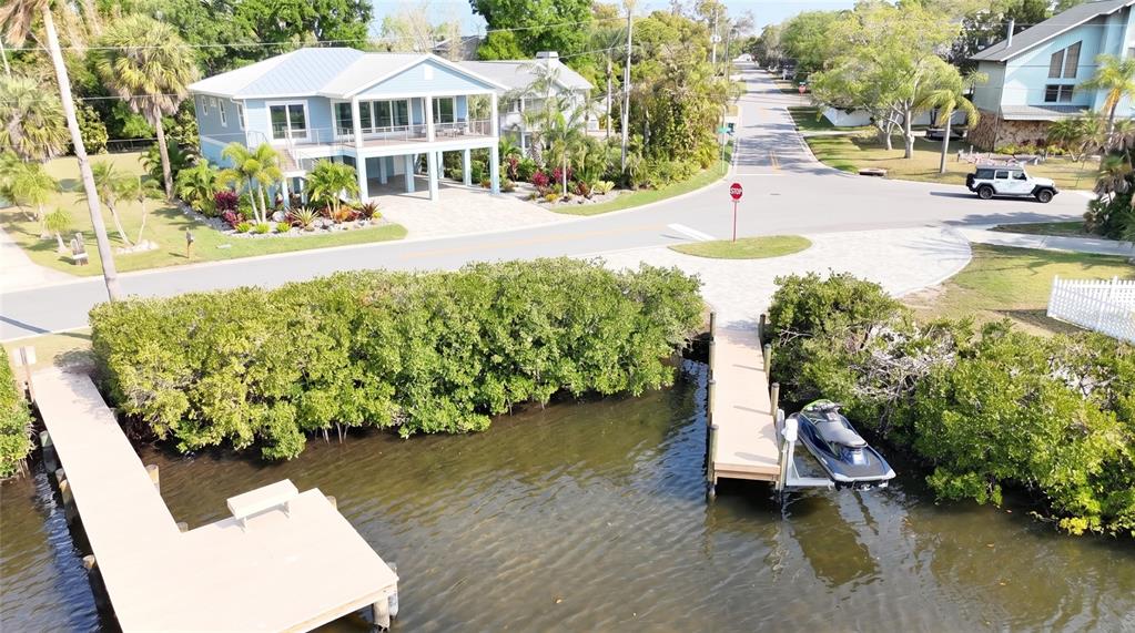 An aerial view shows a waterfront house with two docks and a jet ski lift — 231 LAGOON DRIVE, PALM HARBOR, FL
