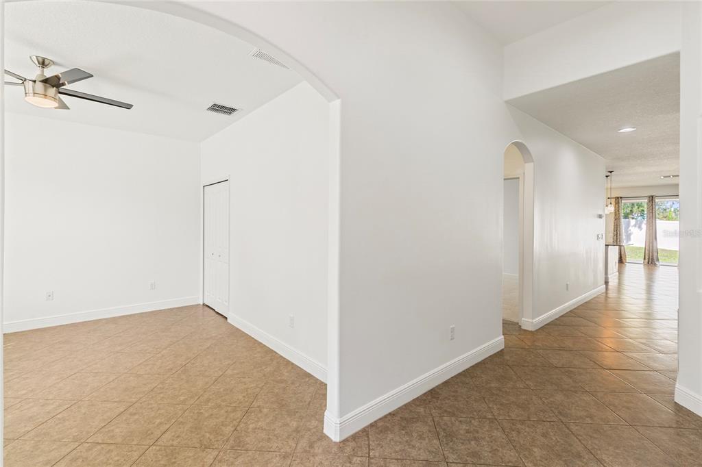 An interior view showing a tiled room with an arched entryway and a ceiling fan — 6706 RIVERSIDE BLUFFS DRIVE, RIVERVIEW, FL