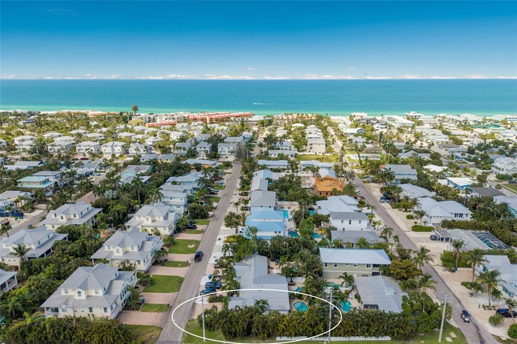 An aerial view shows a coastal neighborhood with a circled house featuring a private pool — 324 64TH STREET, HOLMES BEACH, FL