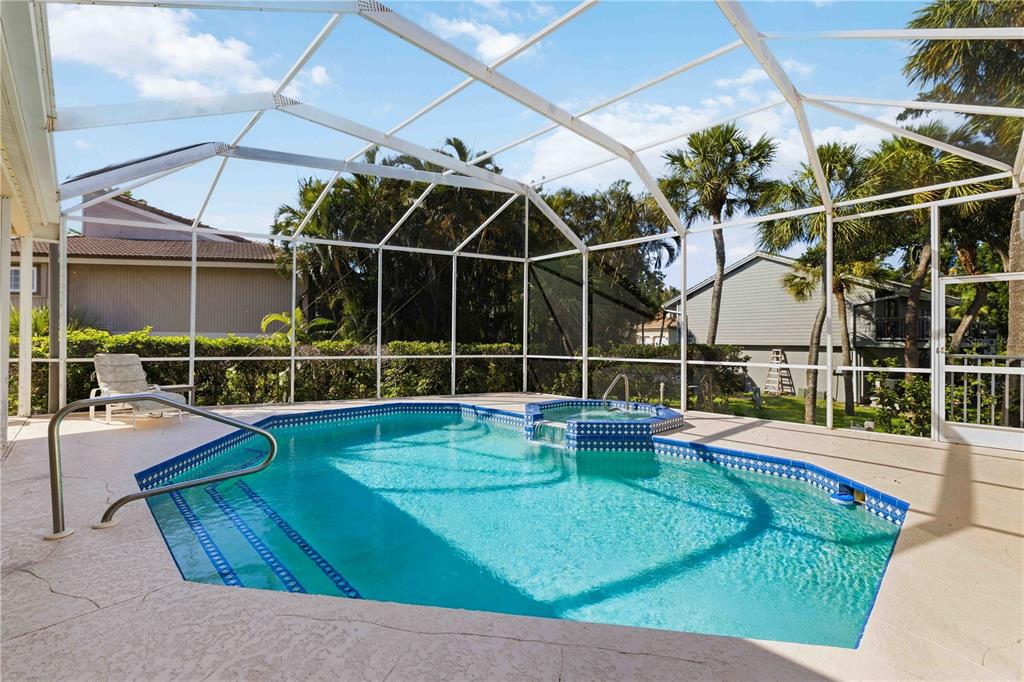 A screened-in swimming pool and attached hot tub on a concrete patio — 3301 BAYOU ROAD, LONGBOAT KEY, FL