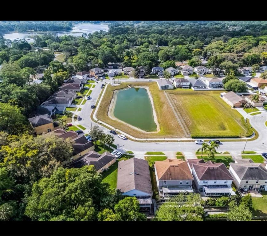 Aerial view of suburban houses bordering a golf course with several ponds and green space — 152 GOLFSIDE CIRCLE, SANFORD, FL