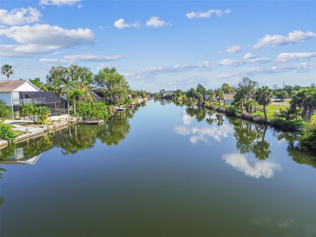 An aerial view of a calm canal lined with houses, trees, and private docks — 3314 FERNLEAF DRIVE, HERNANDO BEACH, FL