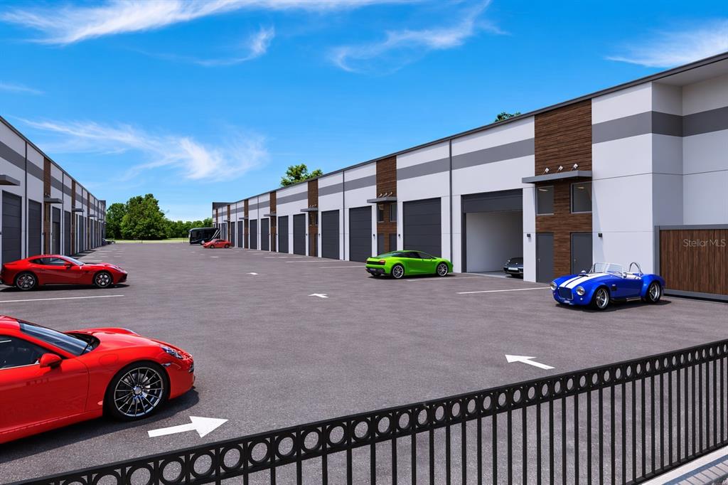 This rendering shows a modern industrial storage complex with multiple garage bays and parked sports cars — 5864 DEREK AVENUE UNIT 1-2, SARASOTA, FL