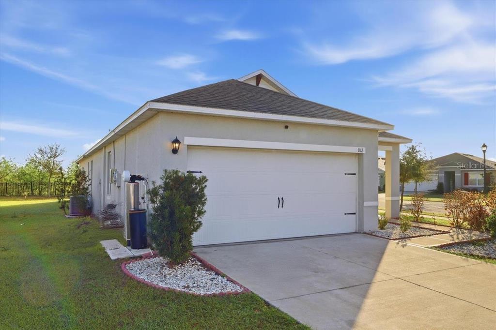 A single-story house with a white garage door and a concrete driveway — 812 BROOKLET DRIVE, DAVENPORT, FL